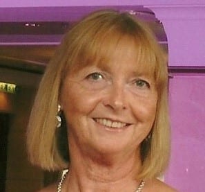 Pink background with a headshot of womens face smiling and blond bob hair